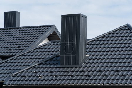 Foto de Techo moderno de metal y chimenea en el techo de la casa. Hermoso techo limpio hecho de perfil de metal. - Imagen libre de derechos