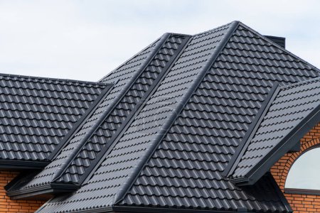 Téléchargez les photos : Maison avec toit en métal noir. Toiture en métal ondulé et toiture en métal. - en image libre de droit