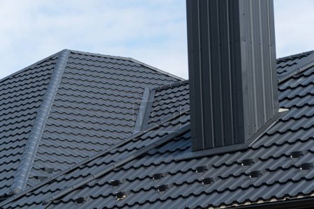 Schwarzmetallprofildach auf einem modernen Haus installiert. Moderne Arten von Dachmaterialien.