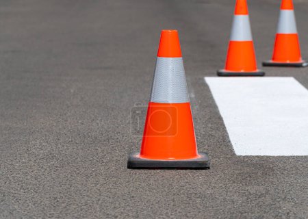 Road traffic cones standing on street on gray asphalt during road construction works. Traffic cones for road works.