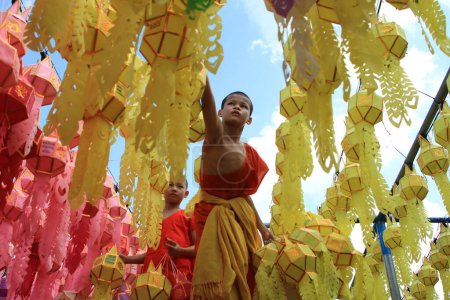 Téléchargez les photos : LAMPHUN THAÏLANDE : 11 novembre 2023 : Les moines bouddhistes et les novices bouddhistes se préparent pour le Festival des cent mille lanternes, ou Festival Yi Peng, à Wat Phra That Hariphunchai, nord de la Thaïlande - en image libre de droit