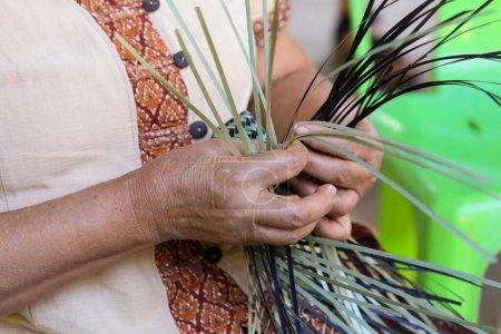 Foto de Una mano de mujer tailandesa teje una canasta ancestral de bambú. La gente está demostrando tejer una cesta tradicional hecha de bambú - Imagen libre de derechos