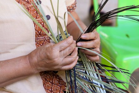 Foto de Una mano de mujer tailandesa teje una canasta ancestral de bambú. La gente está demostrando tejer una cesta tradicional hecha de bambú - Imagen libre de derechos