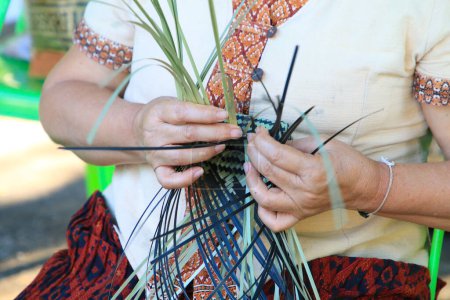 Téléchargez les photos : Une main de femme thaïlandaise tisse un étui à panier ancestral en bambou. Les gens font la démonstration de tissage d'un panier traditionnel en bambou - en image libre de droit