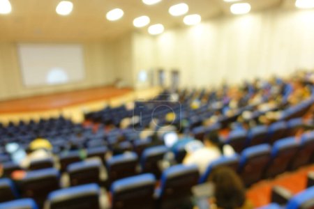 Photo for Blurred or defocused people in the seminar convention hall. Business meeting for a press conference or lecturer education concept with a wide view from the room's corner. Modern, blurry auditorium. - Royalty Free Image