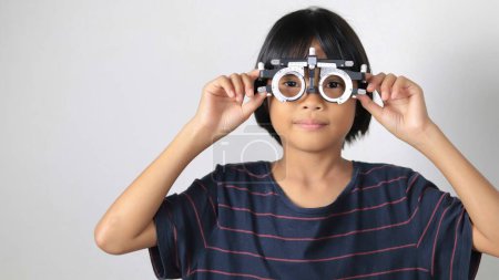 Photo for Child eye exam, kid eye test in optical, kid eye test by Phoropter in hospital - Royalty Free Image