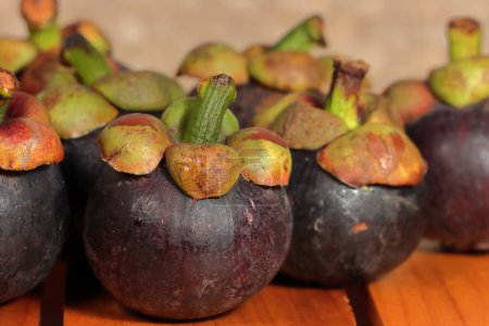 Téléchargez les photos : Ensemble de fruits mûrs de mangoustan sur le fond en bois - en image libre de droit