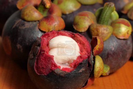Téléchargez les photos : Mangoustan au noyau juteux. La pulpe de fruits est légèrement acide et sucrée. Prévention du cancer fruits - en image libre de droit
