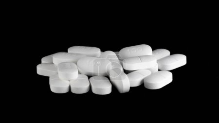 Photo for Pile of Sertraline 100mg pills on black background. Setraline is an SSRI or anti depressant in treatment for depression and anxiety disorders - Royalty Free Image