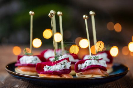 Photo for Christmas canapes with blinis with salmon, pickled beetroot and goat cheese - Royalty Free Image