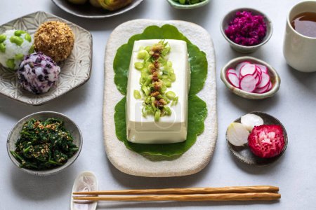 Foto de Almuerzo japonés con tofu de seda, onigiri, espinacas gomae, puerros miso y verduras en vinagre - Imagen libre de derechos