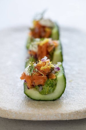 Photo for Party canapes, cucumber boats with avocado and salmon - Royalty Free Image