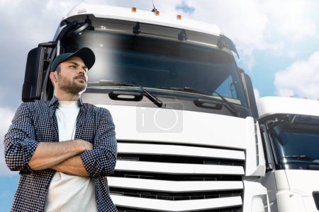 Truck driver standing in front of trucks 
