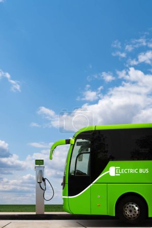 Elektrischer Stadtbus mit Ladestation vor dem Hintergrund des Stadtbildes. Grüner Verkehr und sauberes Mobilitätskonzept 