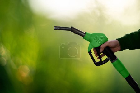 Hand mit Treibstoffdüse mit Aufschrift BIO. CO2-neutrales Konzept zur Dekarbonisierung von Biokraftstoffen