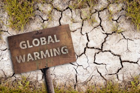 Rusty sign with text GLOBAL WARMING on a background of dry cracked soil. Climate change concept. High quality photo