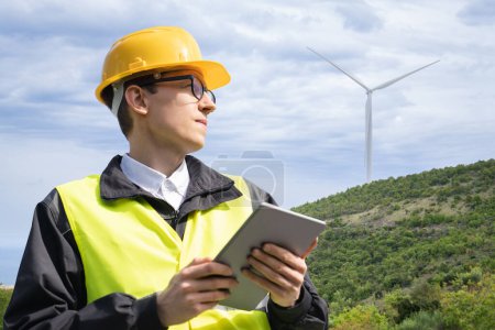 Ingeniero con Tablet PC sobre fondo de turbina eólica