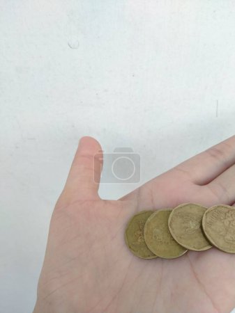 Photo for Hand holding a coin on a white background - Royalty Free Image