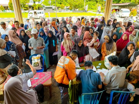 Photo for Pariaman, Indonesia - January 31, 2024: Villagers are queuing to collect rice aid from the government at the North Pariaman sub-district office - Royalty Free Image