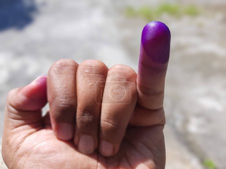 Die Hand eines Mannes, dessen Finger als Zeichen dafür eingefärbt sind, dass er seine Wahlteilnahme beendet hat