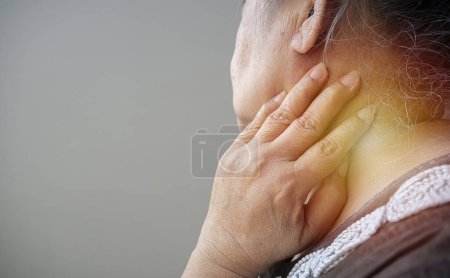 Photo for Crop image of Asian senior woman experiencing neck pain at home. Neck and shoulder pain, old woman suffering from neck and shoulder injury, health problem concept. - Royalty Free Image