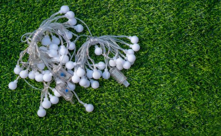 Photo for Festive electric light garland on green grass background. Party garland decoration concept. Top view, copy space. - Royalty Free Image