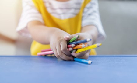 Téléchargez les photos : Image recadrée des mains d'un enfant tenant différents crayons de couleur. Peinture pour enfants et concept de passe-temps, focus sélectif. - en image libre de droit