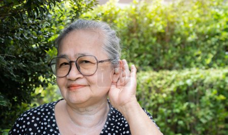 Foto de Imagen de retrato de una mujer asiática mayor feliz que usa anteojos con audífono puesto que finalmente puede escuchar bien. Copiar espacio. - Imagen libre de derechos