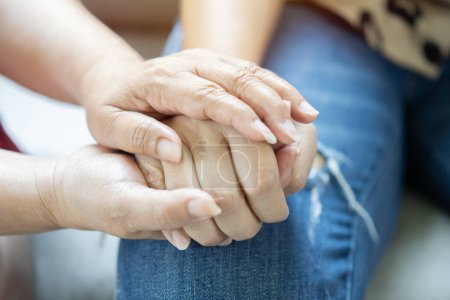Menschen mittleren Alters sitzen drinnen und halten die Hände in Großaufnahme. Ehepartner fühlen Verbundenheit und Liebe, teilen Probleme drücken Empathie aus und zeigen Mitgefühl.