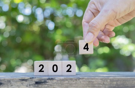 Photo for Business woman hand holding wooden cube with 2024 word on table over nature background. Resolution, strategy, solution, goal, business, New Year New You and happy holiday concepts - Royalty Free Image