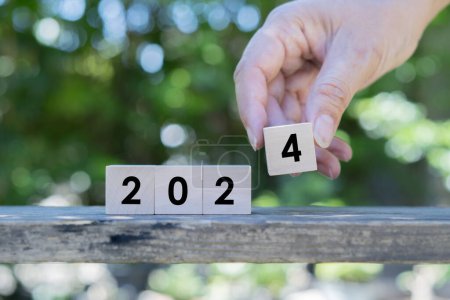 Photo for Wooden block Happy New Year 2024. Wooden block placed on old wooden table over nature background and bokeh. - Royalty Free Image