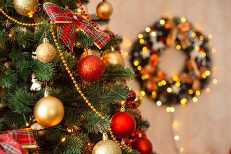 Foto de Primer plano del árbol de Navidad. Árbol de Navidad decorado con adornos, luces en primer plano, corona en el fondo. - Imagen libre de derechos