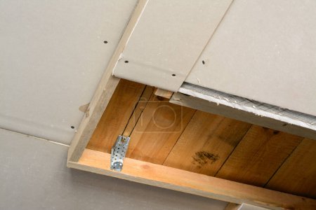 Foto de Sala de construcción con paneles de yeso. Hacer techo suspendido con marco de madera y paneles de yeso en una casa privada - Imagen libre de derechos