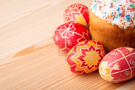 Foto de Celebration Easter in Ukraine. Inked eggs near Paska(traditional Easter bread in Ukraine) on light wooden table with copy space - Imagen libre de derechos
