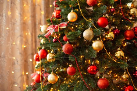 Warm bright lights of garland, festive interior, beautiful christmas tree with round baubles. Winter decoration, new year and christmas time