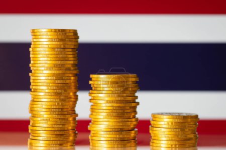 Foto de Golden coin stacks against flag of Thailand. Financial recession of Thailand, negative GDP rate of the country - Imagen libre de derechos
