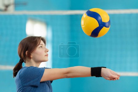 Photo for Female player learning fundamental skills in volleyball. Girl practicing digging to receive and save the ball from hard-given attack of the opponents - Royalty Free Image