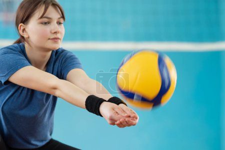 Photo for Photo in action of a girl playing volleyball. Young female mastering volleyball skills on volleyball court - Royalty Free Image