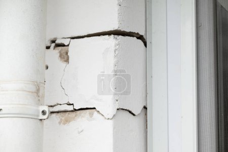 Foto de Muro de ladrillo de una casa con grietas, errores en el edificio. Casa con muchas grietas entre ladrillos, problemas con la fundación de un edificio - Imagen libre de derechos