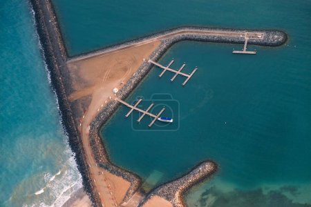 Breakwater wall in the sea, with the boat dock aerial view