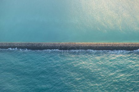 Breakwater wall in the sea, with the boat dock aerial view