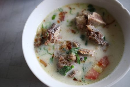 Photo for Sop Djadoel, Sop iga or rib soup on white bowl. made from herbs and spices with cream sauce. Traditional indonesian food. close up. - Royalty Free Image