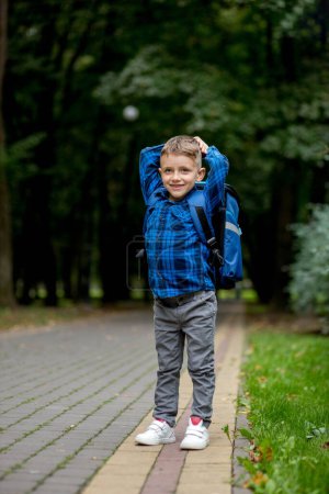 Photo for Portrait of a first grader with a backpack. The boy goes to school. - Royalty Free Image