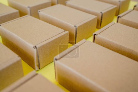Photo for Many cardboard kraft boxes on a yellow background. Packing the parcel - Royalty Free Image
