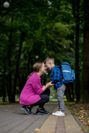 Photo for Young mother embraces her excited first class son on the way to school. Ready to study. - Royalty Free Image