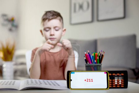Photo for Little boy counting with the help of mental arithmetic. Mathematics in pleasure. - Royalty Free Image