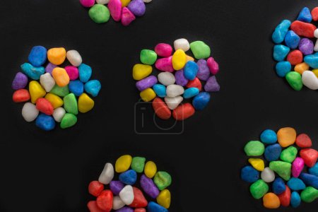 Téléchargez les photos : Pile de petits cailloux colorés sur fond noir - en image libre de droit