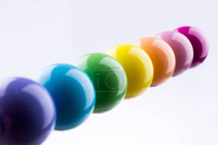Foto de Pequeñas bolas de color en línea sobre un fondo blanco - Imagen libre de derechos