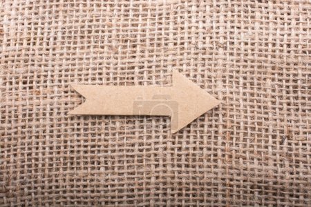 Photo for Arrow sign cut out of brown paper on canvas - Royalty Free Image