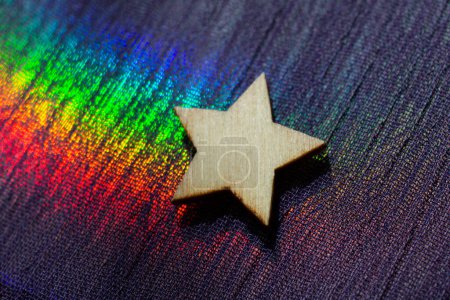 Téléchargez les photos : Forme étoile en bois sur fond de tissu coloré - en image libre de droit